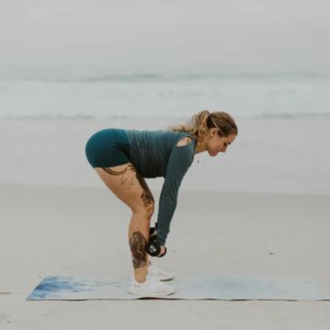Lady in workout on the beach with amp dumbell strength bars