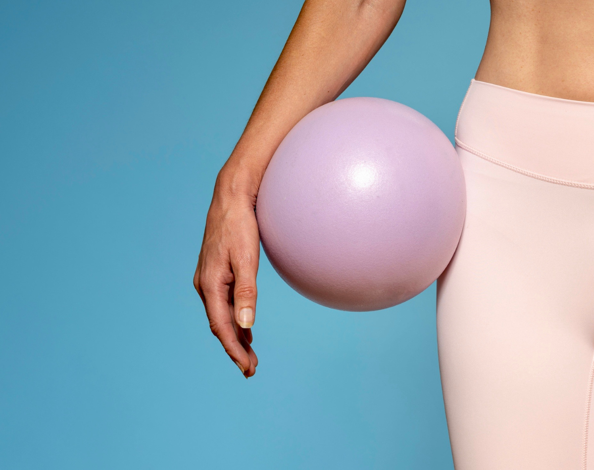 Lady with black pilates weights in home workout position