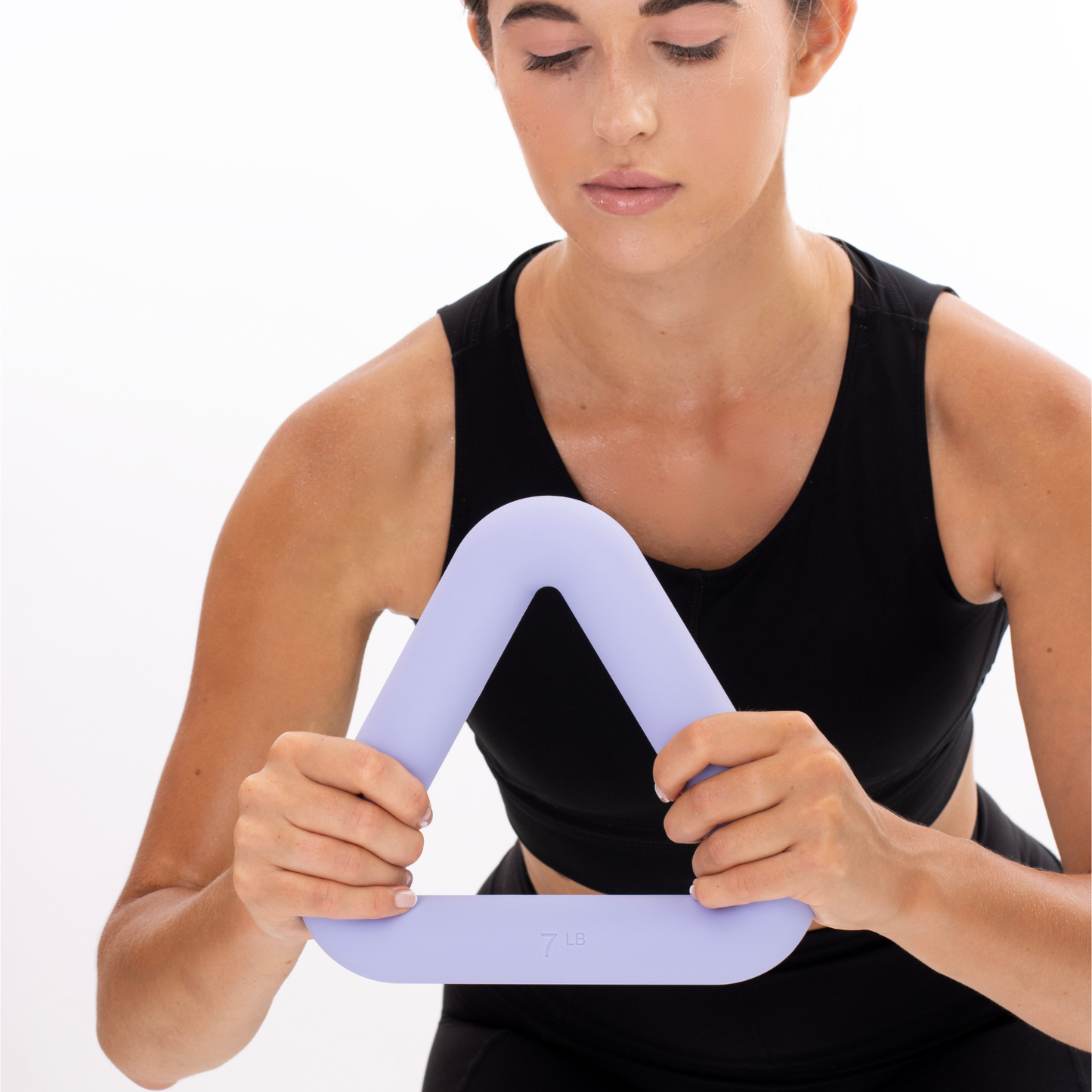 Woman holding a purple resistance weight against a white background