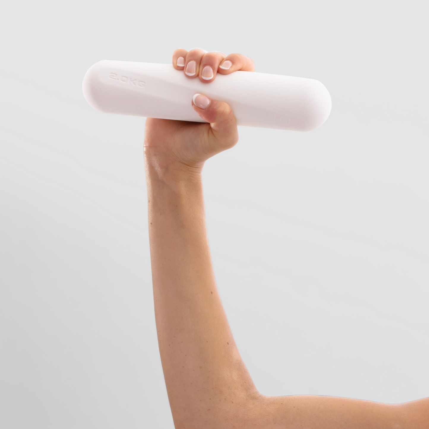 Hand holding a white 2kg dumbbella gainst a light gray background