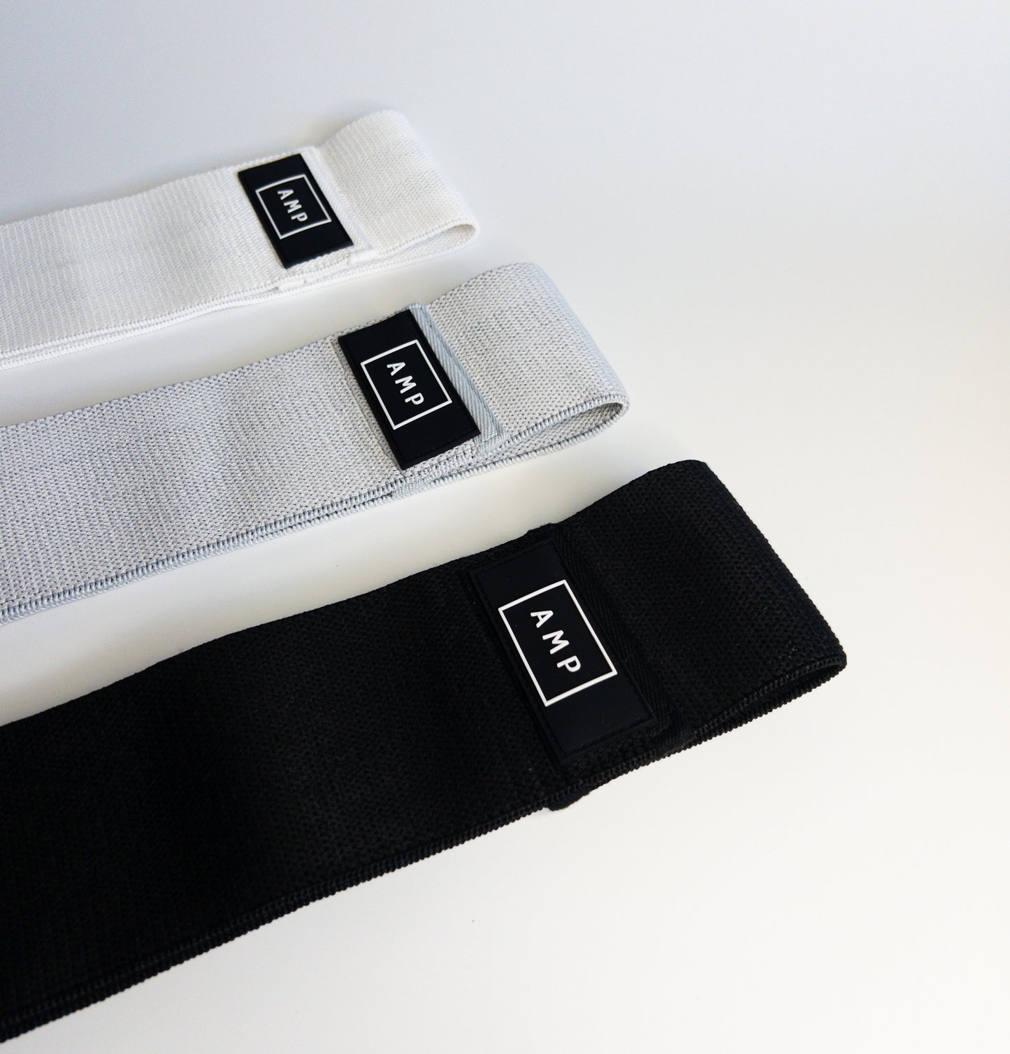 Three loop fabric resistance bands in black, gray, and white