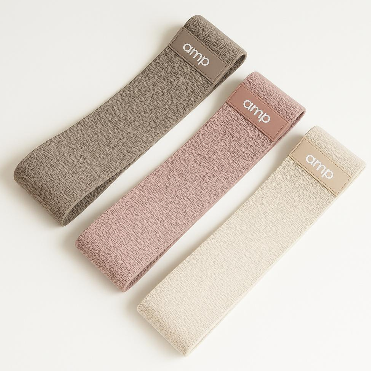 Three fabric straps in beige, pink, and brown with 'amp' branding on a light background
