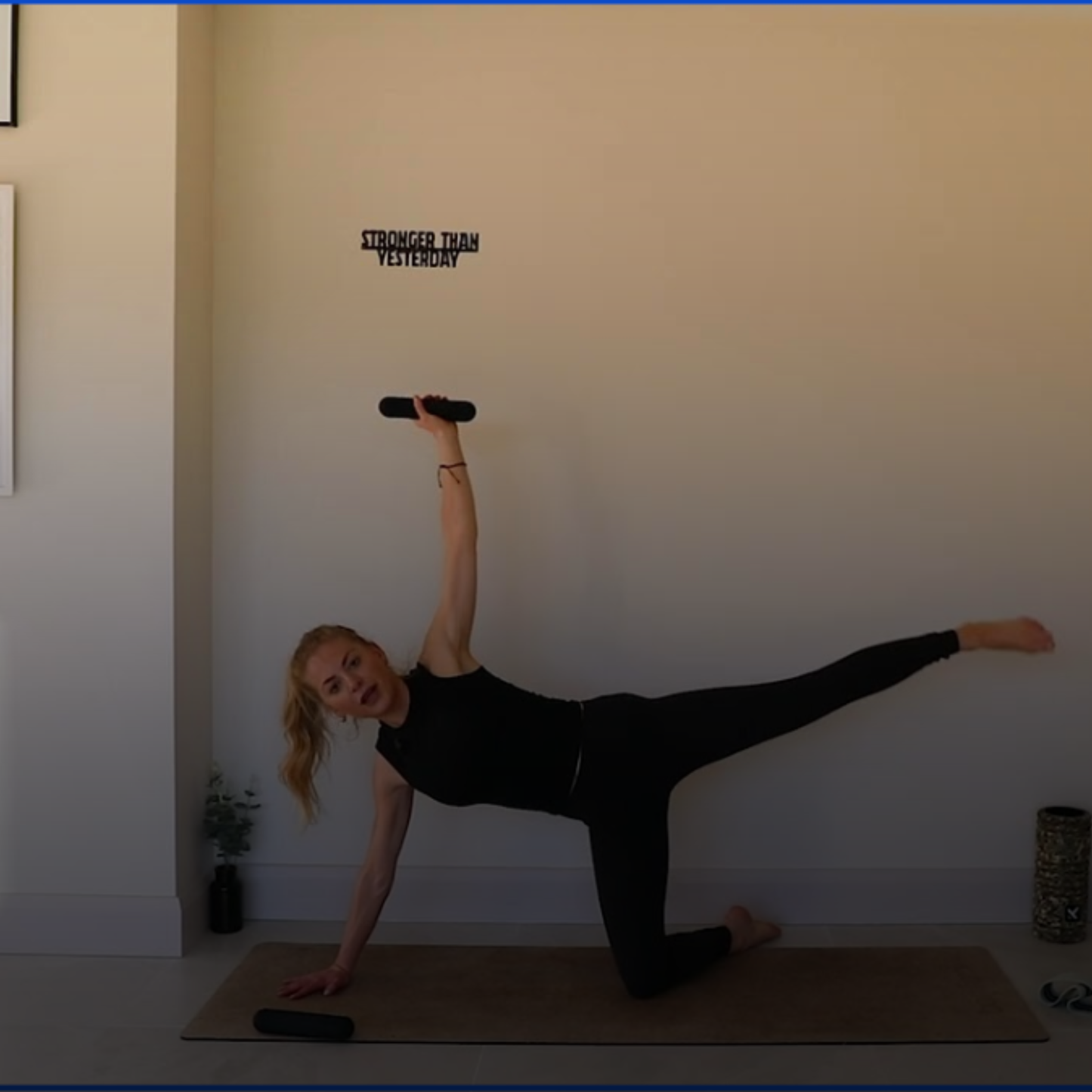 Person in a yoga pose on a mat with a motivational quote on the wall. amp wellbeing pilates equipment